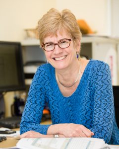 A woman posed at a desk