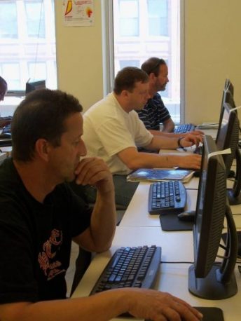 Three men using computers.
