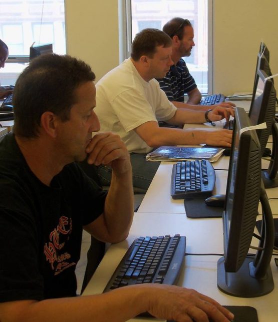 Three men using computers.