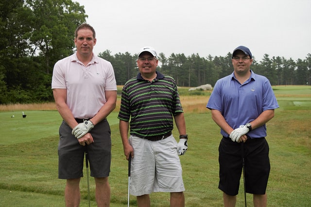 3 men, golf gloves on, standing side by side