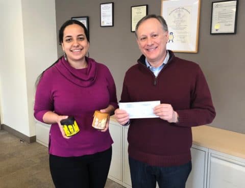 A man and a woman pose with a check