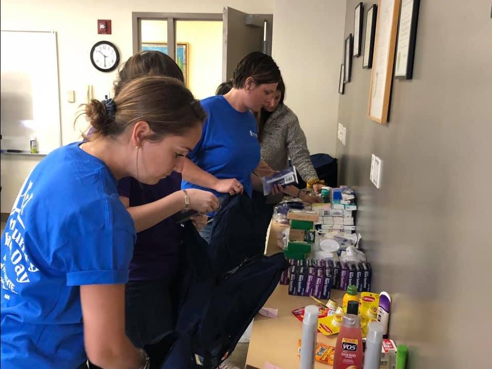 Mass General Hospital students filling backpacks with essential items to be passed out to clients