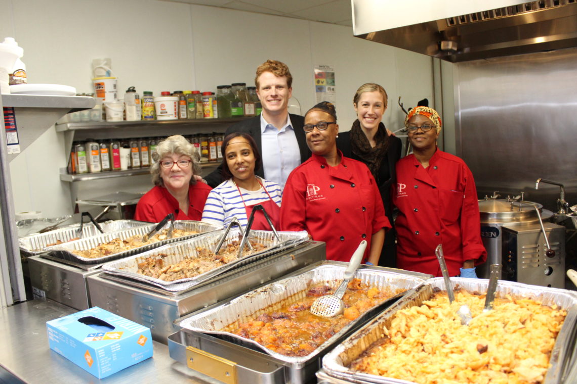 Representative Joseph Kennedy and wife Lauren posing with women of Project Place