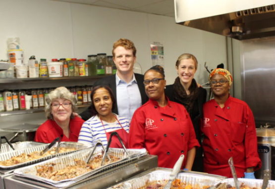 Representative Joseph Kennedy and wife Lauren posing with women of Project Place