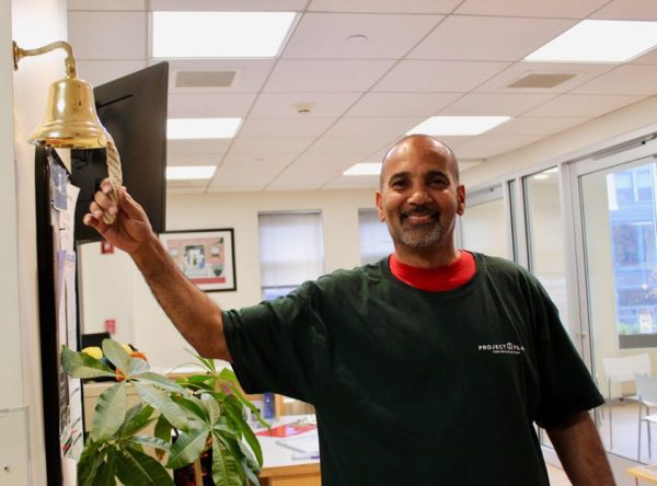 a newly employed client ringing the job bell on the wall